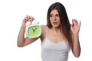 Beautiful sleeping woman resting in bed with alarm clock ready to wake her in the morning. photo