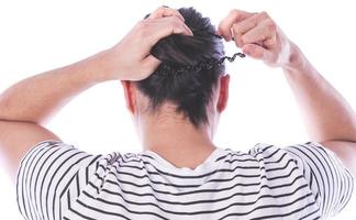 ack view of a man with long hair making ponytail. photo