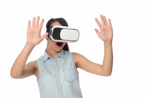 Pretty cute excited female in VR headset looking up and trying to touch objects in virtual reality photo