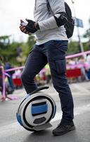 Electric unicycle. Man rides on mono wheel on zebra crossing photo