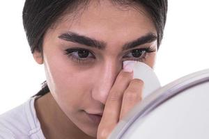 Young beautiful woman cleaning her face with cotton pads photo