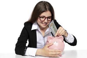 saving concept. beautiful female model saving her money in a piggy bank photo