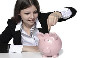 saving concept. beautiful female model saving her money in a piggy bank photo