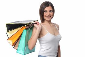 Image of a beautiful young brunette lady posing with shopping bags and looking at camera. shopping concept. Isolated photo