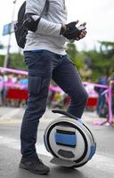 Electric unicycle. Man rides on mono wheel on zebra crossing photo