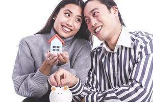 Asian couple saving money in piggy bank photo