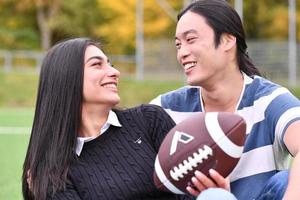 mixed Couple In Park playing American Football. American football. Couple playing Rugby. photo