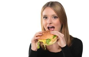 retrato de una hermosa joven divertida comiendo hamburguesas. foto