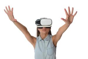 Pretty cute excited female in VR headset looking up and trying to touch objects in virtual reality photo