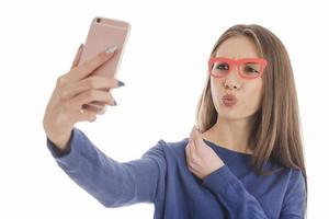 Beauty funny teenage girl making selfie with her cellphone photo