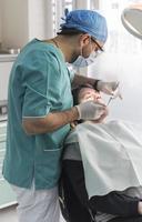 dentist curing patient's teeth filling cavity. Dentist working with professional equipment in clinic. photo