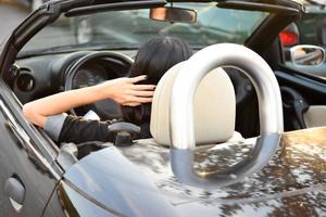 Happy beautiful woman driving a sports car in the city photo