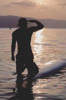 Handsome sporty man is kayaking on sunset photo
