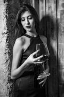 modelo de moda femenina sosteniendo una copa de vino. mujer bebiendo vino. foto