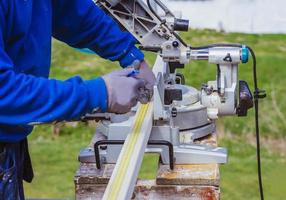 unknown construction worker using with circular saw and plank. construction concept photo