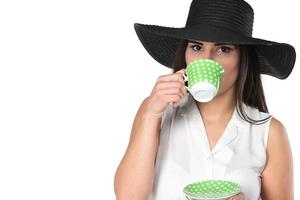 beautiful brunette woman laying in bead holding cup of coffee, tea cup photo