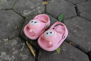 Pink sandals for babies aged 12 months or toddlers on paving blocks photo