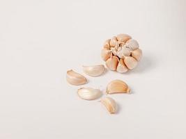 Large head of garlic and small cloves arranged on white background Put yourself aside to have copy space. photo