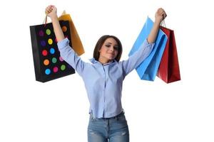 concepto de compras. hermosa morena sonriente con bolsas de compras posando sobre fondo blanco foto