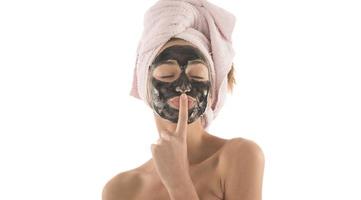 Beautiful girl with black facial cosmetic mask. Beauty concept. isolated photo