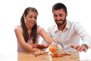 Family savings concept. Beautiful couple home financing. Saving money in the piggy bank. photo