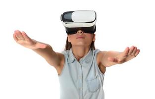 Pretty cute excited female in VR headset looking up and trying to touch objects in virtual reality photo