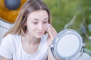 young beautiful woman cleans her face with wet wipes. isolated photo