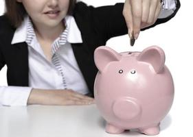 saving concept. beautiful female model saving her money in a piggy bank photo