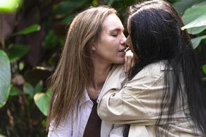 un par de mujeres gay sonriendo y besándose. pareja de mujeres jóvenes casadas del mismo sexo en su rutina diaria mostrando algo de afecto lgbt foto