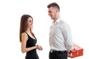 beautiful smiling girl looks at the guy who brought her a gift and keeps behind photo