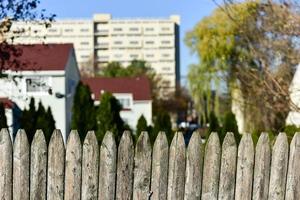 Old wooden picket fence against a city background. photo