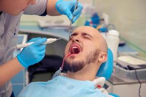 hombre que sufre de dolor de muelas en el dentista foto