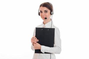 a young girl stands in the headphones with a microphone and holding a black Tablet paper photo