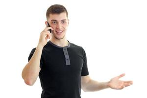 a cheerful young man in a black t-shirt said by mobile phone photo