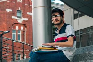 cute pensive guy in glasses holding a book photo
