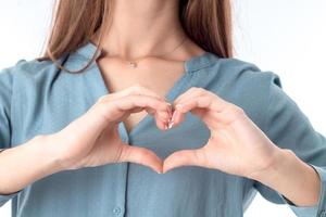 young girl shows a heart-shaped gesture close-up photo