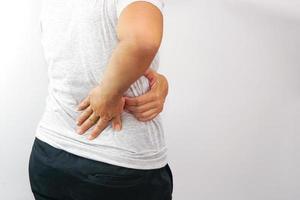 Woman suffering from waist or hip pain on white background. Chronic gastritis, office syndrome and health concept. photo