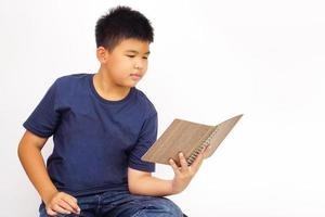 niño sentado felizmente lee un libro. concepto de educación y aprendizaje. foto