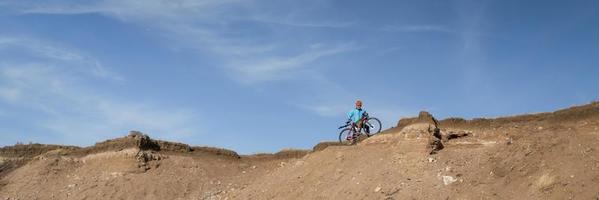 male cyclist is riding a gravel bike on cliff edge photo