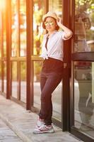 Women wearing hat standing in front of a glass building photo