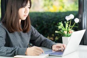 Teenage student using laptop doing homework at home photo