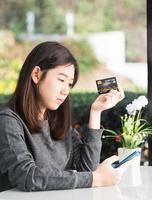 mujer joven, tenencia, tarjeta de crédito, y, utilizar, smartphone foto