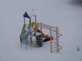 parque infantil cubierto de nieve en invierno foto