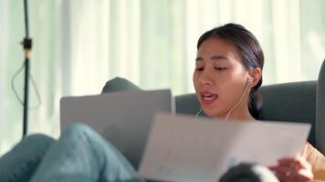 Handheld, Close up shot young woman use earphone and laptop computer to video conference online while work from home