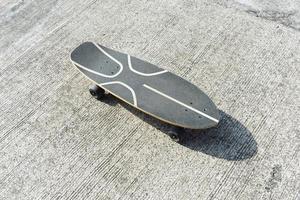 Vista superior de surfskate o monopatín en carretera de hormigón con sombra foto