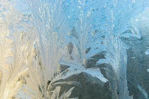 Frozen winter window with shiny ice frost pattern texture. Christmas wonder symbol, abstract background. Extreme north low temperature, natural Ice snow on frosty glass, cool winter weather outdoor. photo