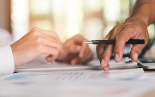 Businessman pointing business statistic chart report, to analyze and improve corporate strategy, manage financial and marketing documents, update annual budget accounts, company growth data. photo