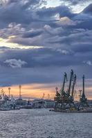 por la noche, la parte del puerto con grúas. Listo para cargar contenedores de buques de carga. foto