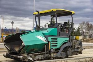 Stopped asphalt spreading machine. Road construction. Applying new hot asphalt using road construction machinery and power industrial tools. photo