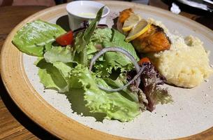 smoked grilled salmon fish served with salad and mash potatoes with lemons photo